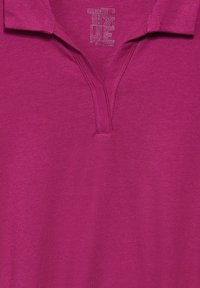 Kortärmad polo i klar magenta med en knappslå med tvåknapps stängning och en texturerad krage. Mjukt tyg.