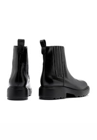 Czarne skórzane botki za kostkę o gładkim wykończeniu, z elastycznymi bocznymi panelami i teksturowaną gumową podeszwą. Posiadają pętelkę do łatwego zakładania.