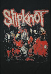 Sort t-shirt med et slidt grafisk design af maskerede figurer iført røde outfits, med "Slipknot" tydeligt vist i en rå hvid skrifttype.