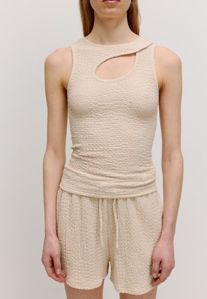 Beige strukturiertes Tanktop mit einem runden Ausschnitt am Hals, kombiniert mit passenden strukturierten Shorts mit einem elastischen Bund.