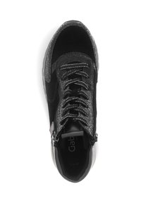 Zwarte sneaker met een mix van materialen: glad leer, gestructureerd suede en een gebarsten afwerking. Witte stiksels en veters zorgen voor contrast.