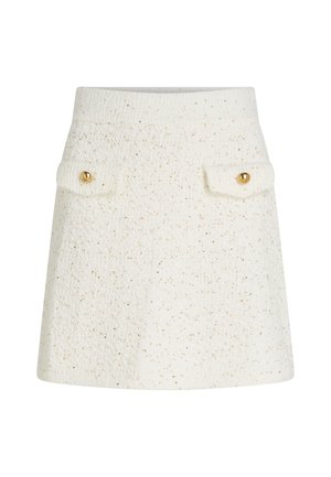 Falda blanca texturizada con sutiles destellos dorados, dos bolsillos frontales con botones dorados y una cinturilla ajustada. Silueta acampanada.