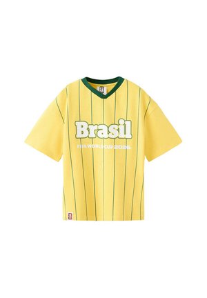 Chemise jaune à manches courtes avec des rayures verticales vertes, un col vert et le texte « Brasil FIFA World Cup 2026 » à l'avant.