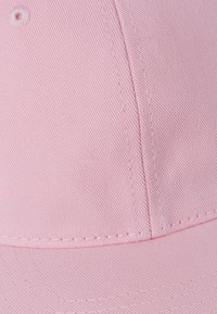 Căciulă de baseball roz dintr-un material texturat, cu cusături vizibile. Are un vârf rotund și un bor fiind drept. Fără embellishments.