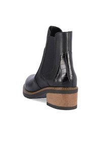 Bottine en cuir noir avec panneaux élastiques sur les côtés, motif crocodile texturé sur le talon, talon en bois et couture contrastante.