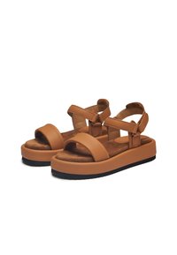 Brown leather sandals with wide straps, adjustable buckles, and a thick cushioned platform sole. Textured footbed for comfort.