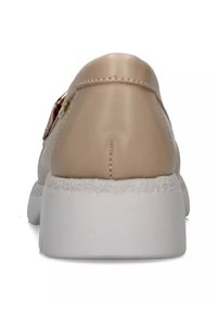 Scarpa sintetica beige con suola in gomma bianca, tacco arrotondato e dettagli metallici tono oro. Tessuto liscio con una finitura uniforme.