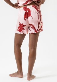 Roze shorts van lichtgewicht stof, met een rood bloemenpatroon. Elastische tailleband, losse pasvorm, boven de knie lengte, met een gladde textuur.