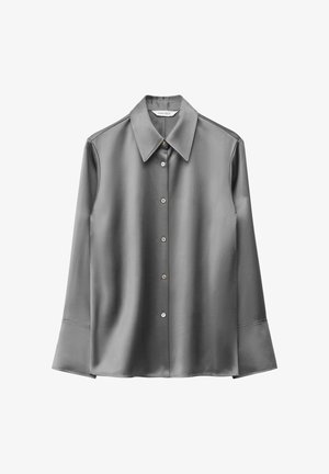 Chemise longue en satin gris à manches longues, dotée d'un col pointu, d'une fermeture à boutons et de détails aux poignets évasés. Texture lisse avec un léger éclat.