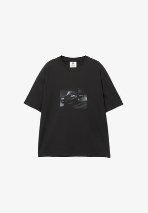 Fekete pamut póló laza fazonnal, elöl autó grafikával. Kerek nyakkivágás és rövid ujjú.