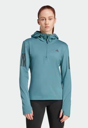 Teal athletic hoodie with a half-zip, adjustable hood, and black three-stripe accents on sleeves. Smooth texture, fitted design.