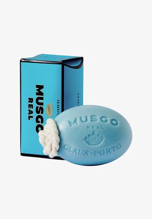 Blaues ovales Seifenstück mit strukturierter Oberfläche und geprägt eingearbeitetem Schriftzug. Enthält ein weißes Seil zum Aufhängen und ist in einer türkisfarbenen Schachtel verpackt.