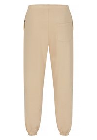 Beżowe dresy wykonane z miękkiego materiału, posiadające elastyczny pasek w talii, ściągacze przy kostkach oraz tylną kieszeń na drobiazgi.