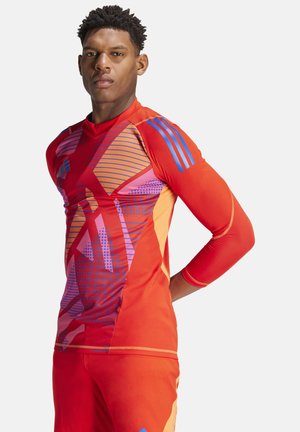 Langarm sportshirt in felrood met paarse en oranje geometrische patronen. Heeft blauwe accenten op de schouders en een slim fit ontwerp.