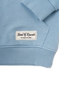 Ljusblå sweatshirt med ribbade muddar och fåll, med en vit tygtagg som visar "Band of Rascals" och "Finest Organic Kids Clothes."