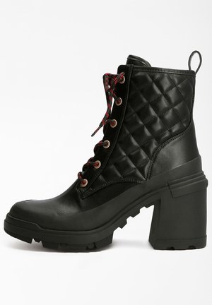 Bottine en cuir matelassé noir avec talon épais, lacets rouges et noirs, et semelle crantée robuste, vue de côté sur fond blanc.