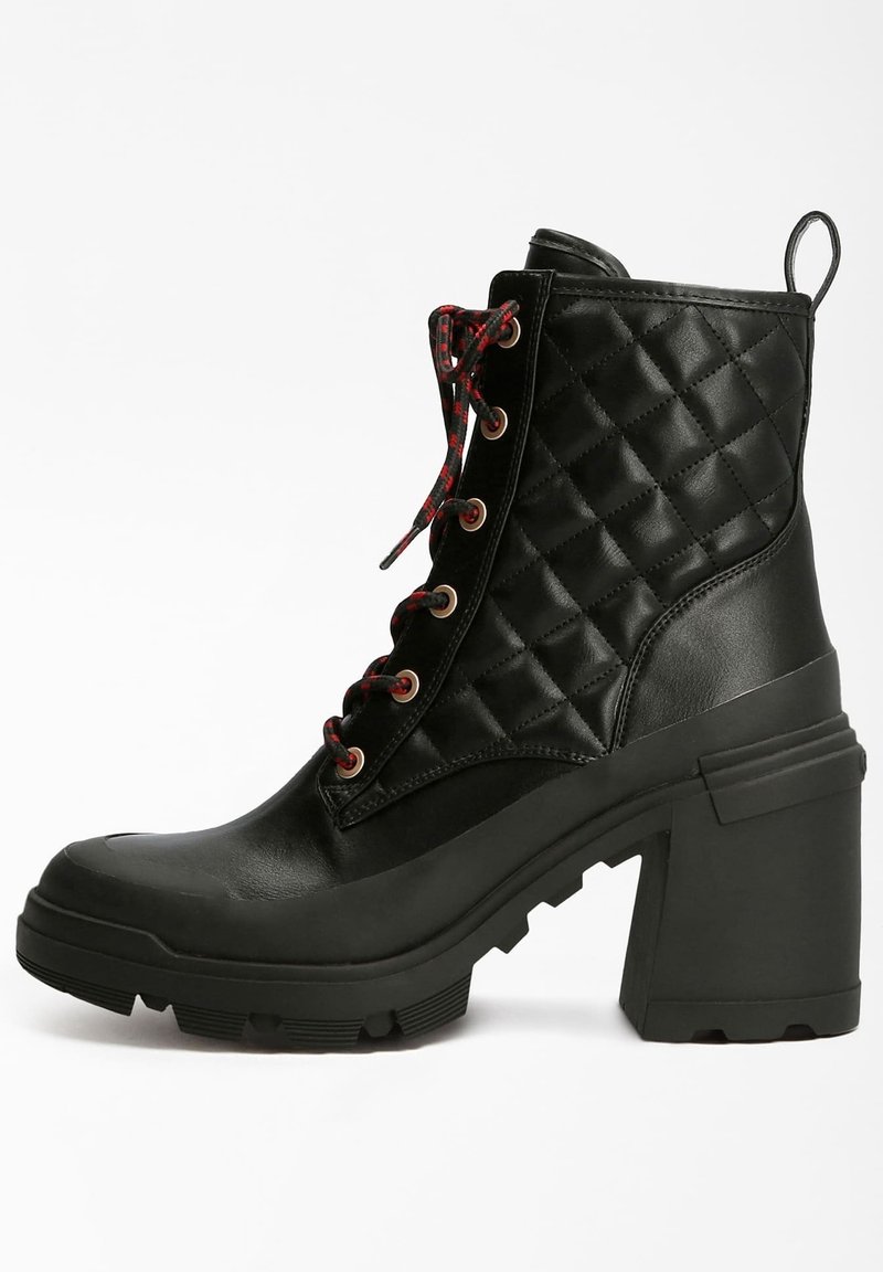Bottine en cuir matelassé noir avec talon épais, lacets rouges et noirs, et semelle crantée robuste, vue de côté sur fond blanc.