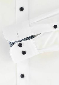 Weißes Hemd mit kontrastierenden gemusterten Manschetten und schwarzen Knöpfen. Glatte Textur, klassischer Kragen und maßgeschneiderte Passform.
