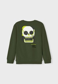 Felpa verde con polsini a coste, caratterizzata da una grande grafica di un teschio in giallo e nero, con testo descrittivo sotto il design.