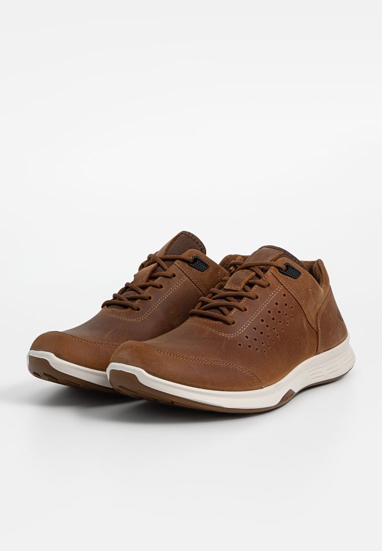 Braune Leder-Sneaker mit durchbrochenen Akzenten, kontrastierenden weißen Sohlen, runden Schnürsenkeln und einer glatten Oberfläche. Das Design ist lässig und niedrig profiliert.