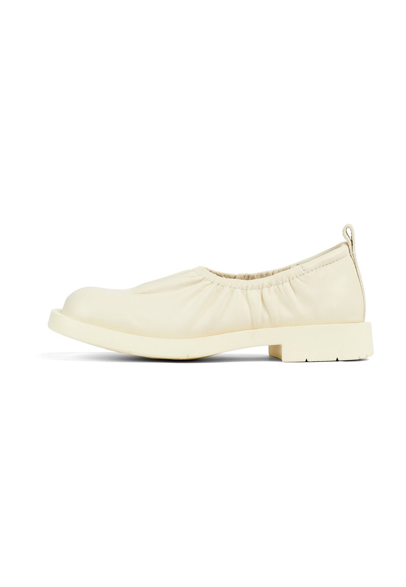 Beige ballet flats with a gathered textile upper, rounded toe, and a low block heel. Textured sole and small pull tab at the back.