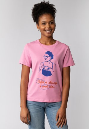 T-shirt en coton rose avec un design illustré bleu d'une femme tenant une tasse, avec le texte "Le café est toujours une bonne idée" en orange.