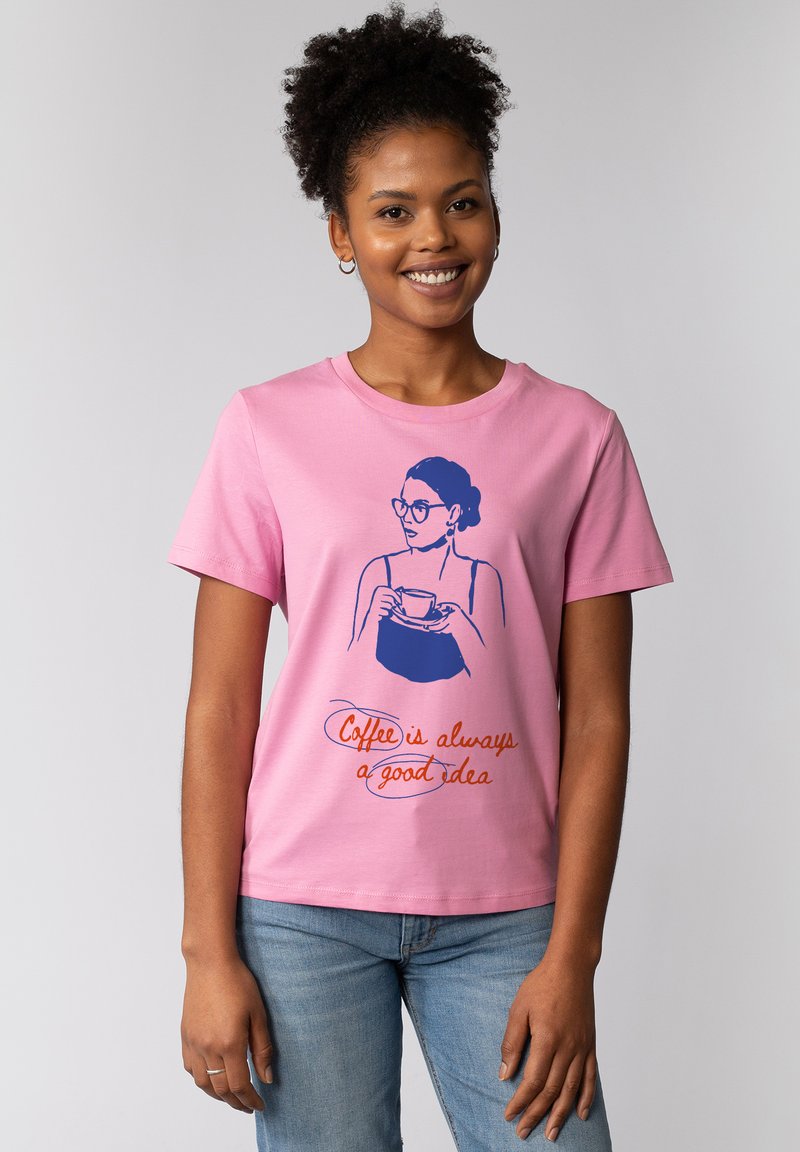 Roze katoenen t-shirt met een blauwe geïllustreerde afbeelding van een vrouw die een kopje vasthoudt, met de tekst "Koffie is altijd een goed idee" in oranje.