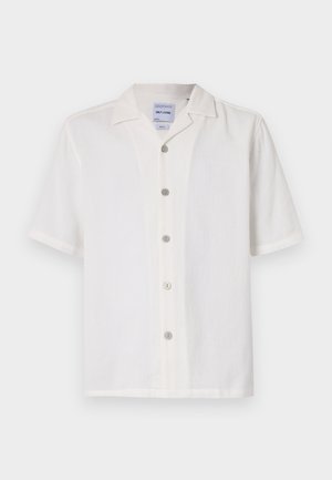 Chemise blanche à manches courtes avec un tissu texturé, col en V et six boutons sur le devant. Présente un design épuré et simple.