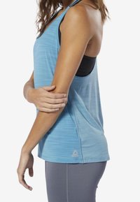 Light blue athletic tank top with a racerback design, featuring subtle horizontal stripes and a small logo near the hem.