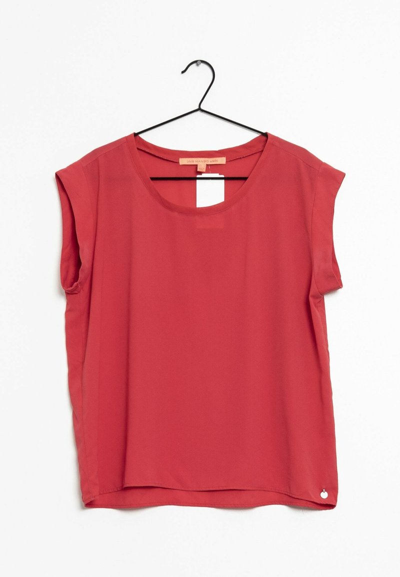 Blouse rouge sans manches avec encolure ronde suspendue à un cintre noir sur un fond blanc.
