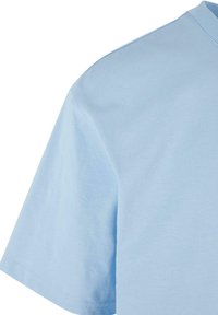 Pale blue trumpas rankovės marškinėliai su apvalia apykakle, pagaminti iš minkštos medvilnės audinio, pasižymintys glotniu tekstūriniu paviršiumi ir tvarkingais siūlais.