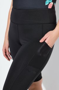 Zwarte sportieve leggings met een hoge taille, voorzien van een zijvak en gestructureerde panelen. Het materiaal lijkt rekbaar en soepel.