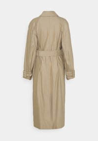 Cappotto beige con vita sfrangiata, maniche lunghe e colletto. Tessuto liscio con cuciture visibili e dettagli con cinturino sui polsini.