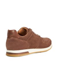 Brown suede sneaker with a smooth leather heel, white midsole, and gum outsole. Features textured detailing and traditional lacing.