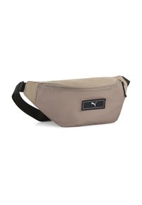 Riñonera beige hecha de tela texturizada con cierre de cremallera, que presenta un parche negro con el logo y una correa ajustable.