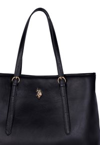 Borsa a tracolla nera in pelle con due manici corti, dettagli in oro e un piccolo logo dorato sul davanti. Texture liscia e forma rettangolare.