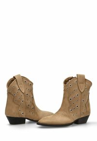 Botas de tobillo de ante marrón con detalles perforados, bordes ondulados y ojales plateados. Presentan una punta afilada y un tacón bajo en bloque.