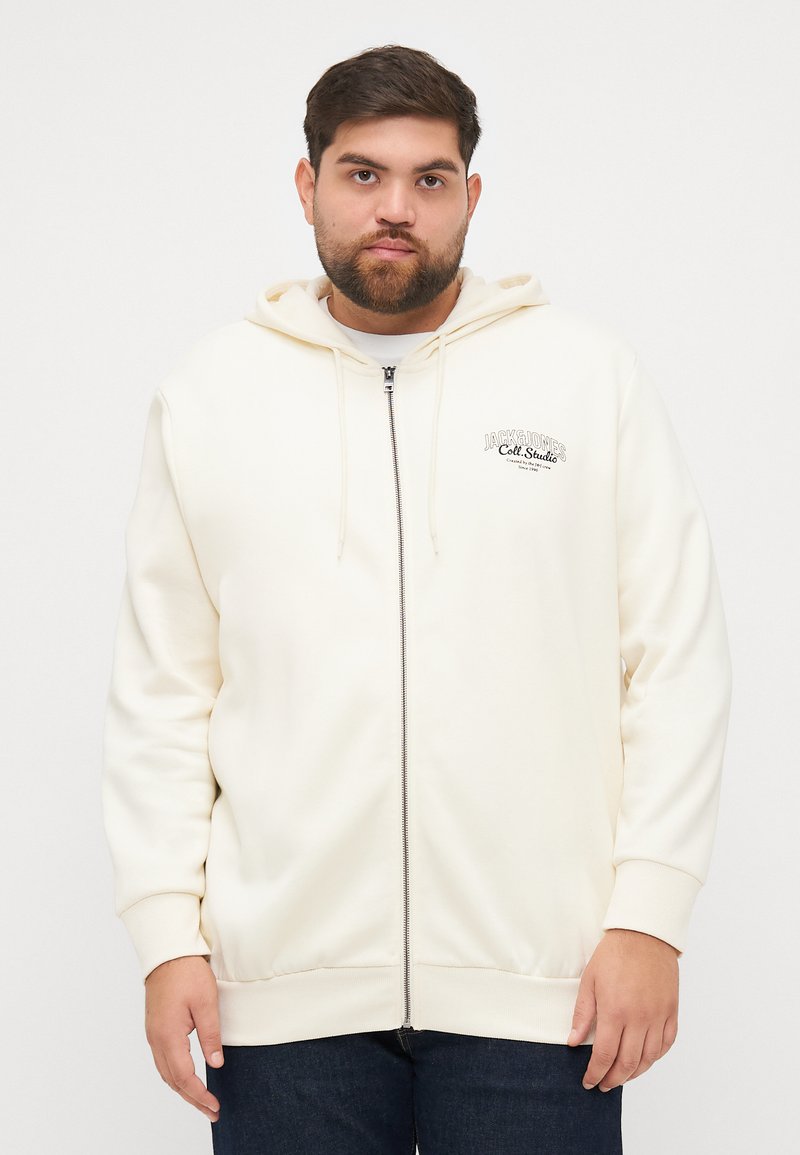 Kremfarget zip-up hettegenser laget av myk stoff, med snor i hetten og brodert logo på brystet. Ribbestrikkede mansjetter og nederkant.
