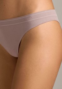 Svjetlomalinaste gaćice bez šavova s mekanom teksturom, tanke elastične trake u struku i suptilan detalj s markom.