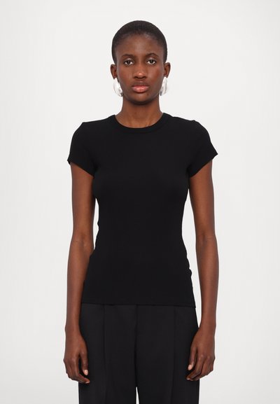 Zwarte nauwsluitende T-shirt met korte mouwen, ronde halslijn en ribbelstructuur, gecombineerd met hooggetailleerde zwarte broek.
