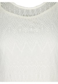 Top bianco in pizzo con scollatura rotonda, motivi floreali intricati e finitura testurizzata con orlo scallop.