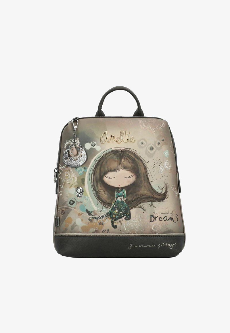 Un sac à dos multicolore avec un design de personnage, présentant une fille dans une robe verte, une poignée noire et des charms décoratifs. Le texte indique "Tu es fait de magie."