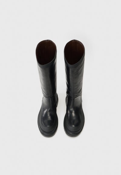 Svart läder knähöga stövlar med en slät yta, rund tå och kraftig sula. Inredningen är klädd i brunt med en subtil glans.
