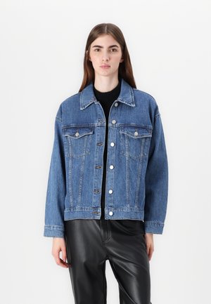 Veste en denim bleu clair avec un col classique, devant à boutons, deux poches poitrine, et une coupe courte, associée à un pantalon en simili cuir noir.