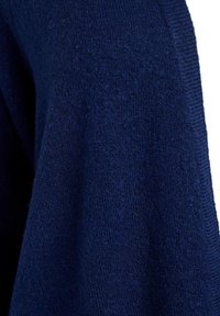 Tissu de pull en tricot bleu marine avec une texture douce, mettant en avant un col côtelé lisse et des coutures qui créent une coupe décontractée.