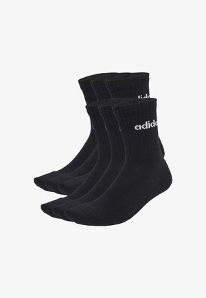 Seis pares de calcetines negros de caña corta con puños acanalados, que presentan el logotipo blanco de Adidas en los laterales, dispuestos en dos filas sobre un fondo blanco.