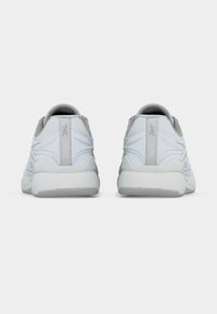 Ζεύγος λευκών αθλητικών παπουτσιών Reebok, εμφανιζόμενα από πίσω σε απλό λευκό φόντο, με υφή στο μέσο της σόλας και θηλιές στο πίσω μέρος.