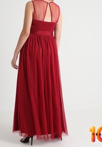 Lång röd klänning med ett genomskinligt ryggparti och smockad byst, samt en flödande tyllkjol. Designen har även en knappstängning bak.