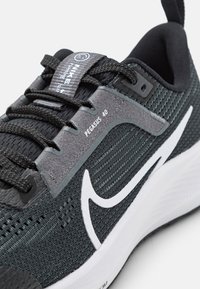 Sneaker Nike Pegasus 40 in nero e grigio con parte superiore in mesh testurizzato, logo swoosh bianco prominente e stringhe piatte.