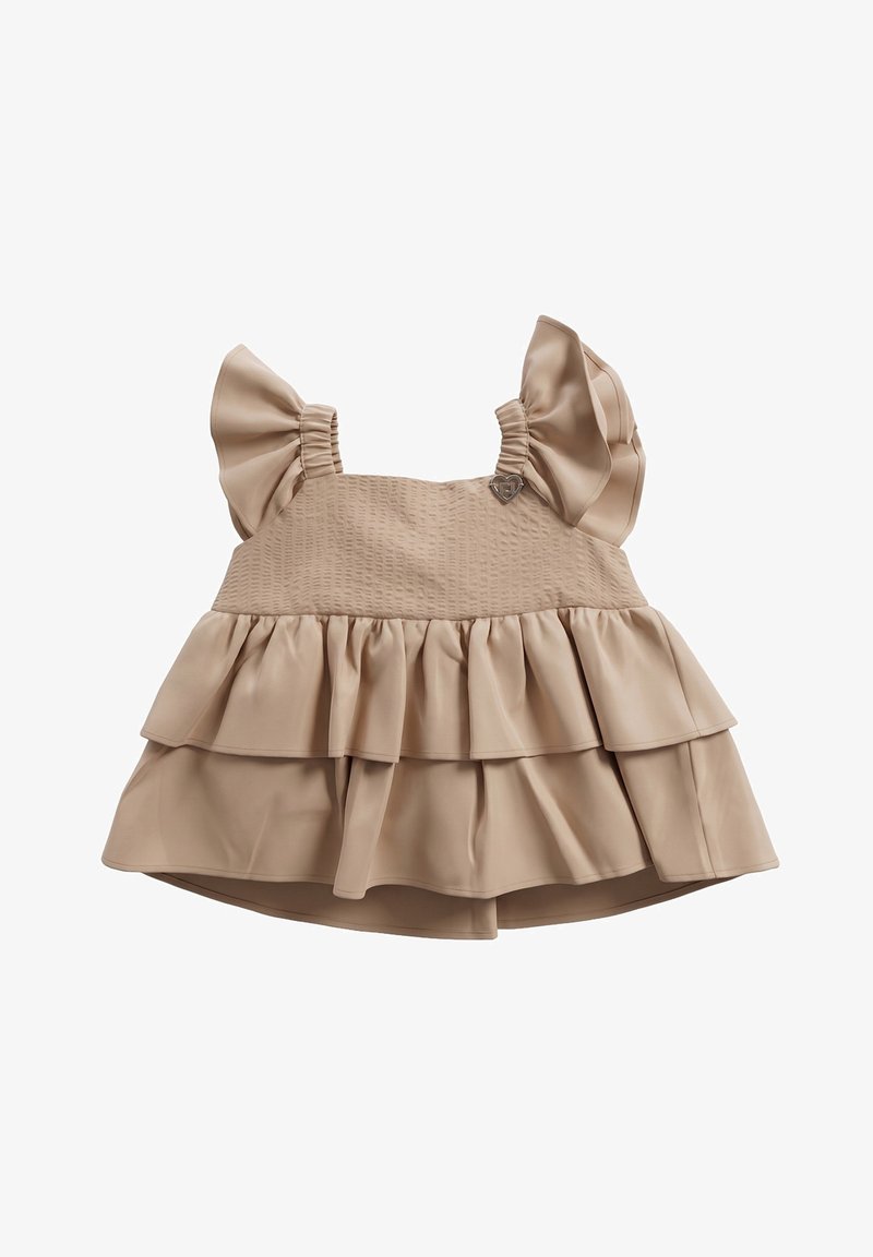 Vestito beige senza maniche per bambino con spalline arricciate, corpino strutturato e gonna svasata a strati, con piccolo ciondolo metallico a forma di cuore.